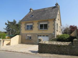 a large brick house with a stone wall at Vers le port in Créhen