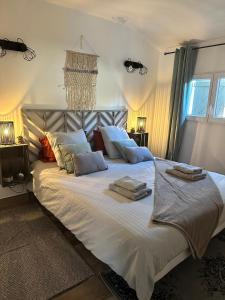 ein Schlafzimmer mit einem großen Bett mit Handtüchern darauf in der Unterkunft Maisonnette Du Mas Vert in Montaren-et-Saint-Médiers
