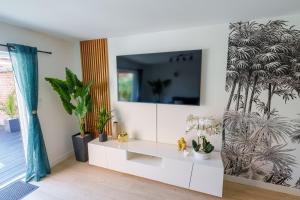 En tv och/eller ett underhållningssystem på L'Escale Tropicale, appartement indépendant avec terrasse privative
