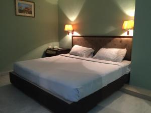 Hotel City Inn في شيتاغونغ: غرفة نوم بسرير كبير عليها شراشف ووسائد بيضاء