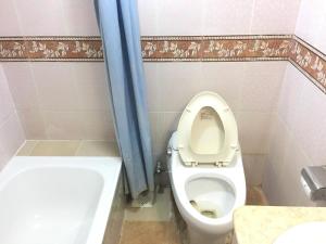 a bathroom with a toilet with a blue shower curtain at Hotel City Inn in Chittagong