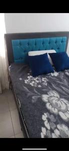 a bed with a blue head board and blue pillows at Segovia apartment in Bogotá