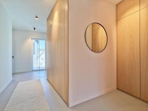 a hallway with a round mirror on a wall at Style pur: Designer-Wohnung in Top-Lage! in Wittlich