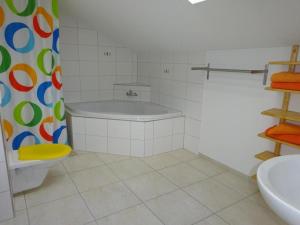 a bathroom with a tub and a toilet and a sink at Rehalp Osten - b48306 in Bischofszell