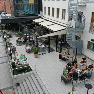 een groep mensen die aan tafels buiten een gebouw zitten bij Fritiden Hotell & Kongress in Ystad