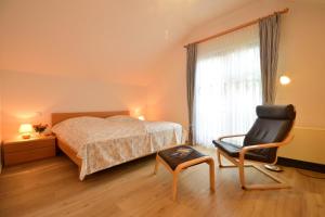 een slaapkamer met een bed en een stoel bij Ferienwohnung Gartenblick am Schweriner See in Schwerin