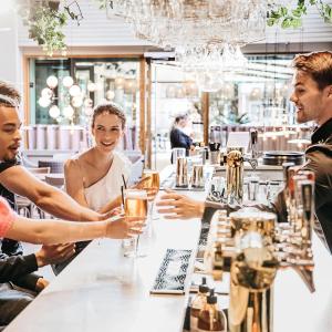 a group of people sitting around a table in a restaurant at Fritiden Hotell & Kongress in Ystad