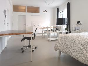 een slaapkamer met een bed en een tafel en een keuken bij appartamenti olivo in Vigevano