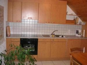 a kitchen with wooden cabinets and a sink and a dishwasher at Bauernhof Bättwil - b48307 in Burgdorf