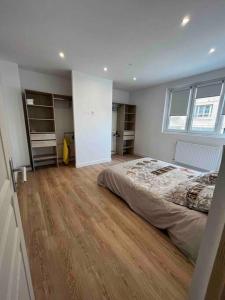 una camera con letto e pavimento in legno di Loft à deux pas de la plage a Dunkerque