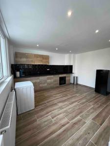 a large room with a kitchen with wooden floors at Loft à deux pas de la plage in Dunkerque