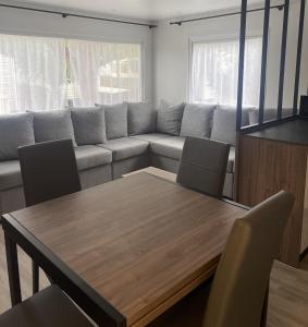 a living room with a table and a couch at Mobil Home Palmiers 1 in Valras-Plage