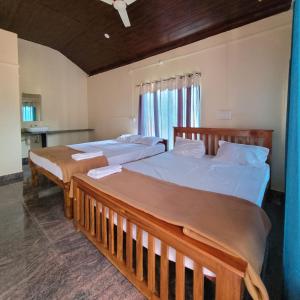 two beds in a room with two beds sidx sidx sidx sidx at The Stone Cabin Cottage in Gokarna