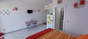 a bedroom with a bed and a table and a refrigerator at Monolocale sul Lungomare San Foca in San Foca