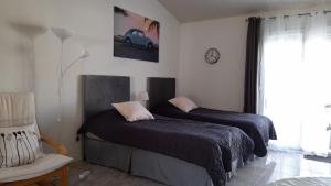 une chambre avec deux lits et une chaise et une fenêtre dans l'établissement Atlantic Residence Studios, à Jonzac