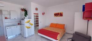 a small bedroom with a bed and a refrigerator at Monolocale sul Lungomare San Foca in San Foca