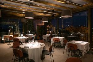 een restaurant met witte tafels, stoelen en ramen bij Quel Castello di Diegaro in Cesena