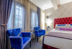In Pera Boutique Hotel في إسطنبول: غرفة فندق بسرير وكراسي زرقاء