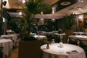 a restaurant with white tables and chairs and plants at Quel Castello di Diegaro in Cesena +36 photos