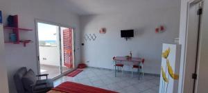 a living room with a table and a television on the wall at Monolocale sul Lungomare San Foca in San Foca