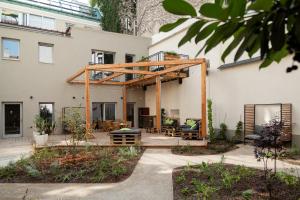 a large white house with a wooden pergola at Urban Jungle Apartments in Vienna