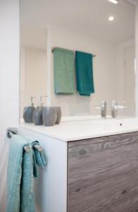 La salle de bains est pourvue d'un lavabo et de serviettes vertes. dans l'établissement Ferienwohnung Brandholz - b48310, à Ebnat