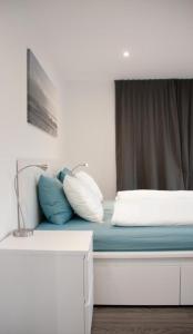 - un lit avec des oreillers bleus et blancs dans l'établissement Ferienwohnung Brandholz - b48310, à Ebnat