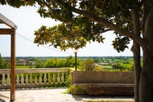 a bench under a tree next to a fence at Residenza Giancesare Family Apartments in Paestum