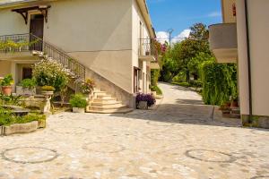 una calle vacía en un edificio con escaleras y flores en Residenza Giancesare Family Apartments, en Paestum