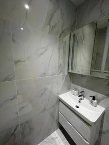 a white bathroom with a sink and a mirror at Dralda House in Buckinghamshire