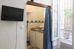 małą kuchnię z telewizorem i oknem w obiekcie Bright studio located near Paris w mieście Pantin