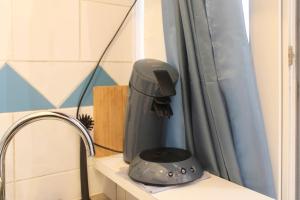 a hair dryer sitting on a shelf next to a window at Bright studio located near Paris in Pantin