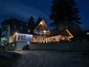 Una casa iluminada por la noche con luces encendidas en Apartments Mountain Joy, en Travnik