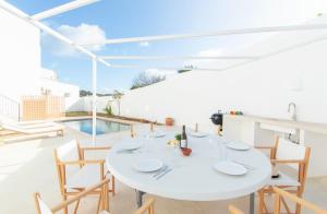 een witte eetkamer met een witte tafel en stoelen bij Casa Lluminosa, fabulosa y moderna casa de pueblo by Sonne Villas in Ferreries