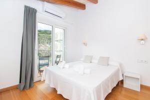 a white bedroom with a bed and a large window at Casa Lluminosa, fabulosa y moderna casa de pueblo by Sonne Villas in Ferreries +102 photos