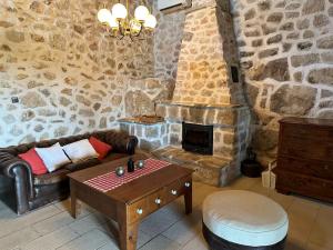 a living room with a couch and a stone fireplace at Paradise cottage in Vinišće