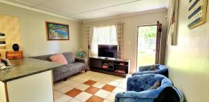 - un salon avec un canapé et une télévision dans l'établissement eagles inn, à Richards Bay