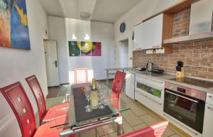 cocina con mesa de cristal y sillas rojas en Apartment Ken near Terme Paradiso en Dobova