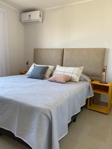 a bedroom with a large bed with a white comforter at Departamento espacioso en Salta in Salta +4 photos
