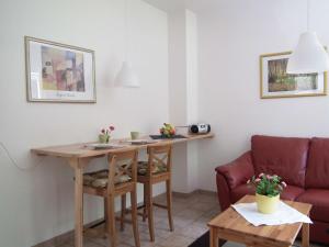uma sala de estar com uma mesa e um sofá em Ferienwohnung Nexö, 30 qm, ein Schlafzimmer N1 em Ilsenburg