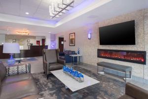 a living room with a fireplace and a flat screen tv at Comfort Inn in Orange