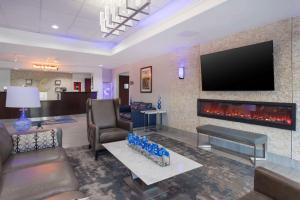 a living room with a fireplace and a flat screen tv at Comfort Inn by Choice Hotels Orange, TX in Orange