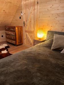een slaapkamer met een bed en een tafel met een lamp bij Sauna House Smyczyna in Smyczyna