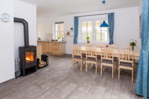 - une salle à manger avec une table et un poêle à bois dans l'établissement Ferienhäuser Ilsestein Einzelhaus, 130 qm, 4 Schlafzimmer, à Ilsenburg