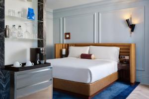 a bedroom with a bed with a coffee maker and a microwave at W Rome in Rome