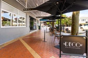 an empty sidewalk with tables and umbrellas on a street at CH Boutique Hotel, Ascend Hotel Collection in Tamworth