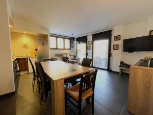 een keuken en een woonkamer met een houten tafel en stoelen bij 5. APT encantador en Canillo. in Canillo