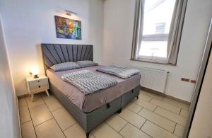 a bedroom with a bed and two windows at Apartment Ken near Terme Paradiso in Dobova