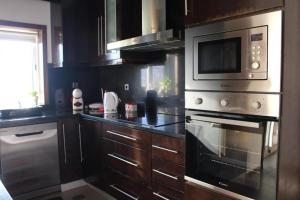 a kitchen with a stove and a microwave at Casa da Barragem in Marco de Canaveses