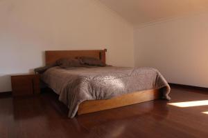 a bedroom with a bed in a room with wooden floors at Casa da Barragem in Marco de Canaveses